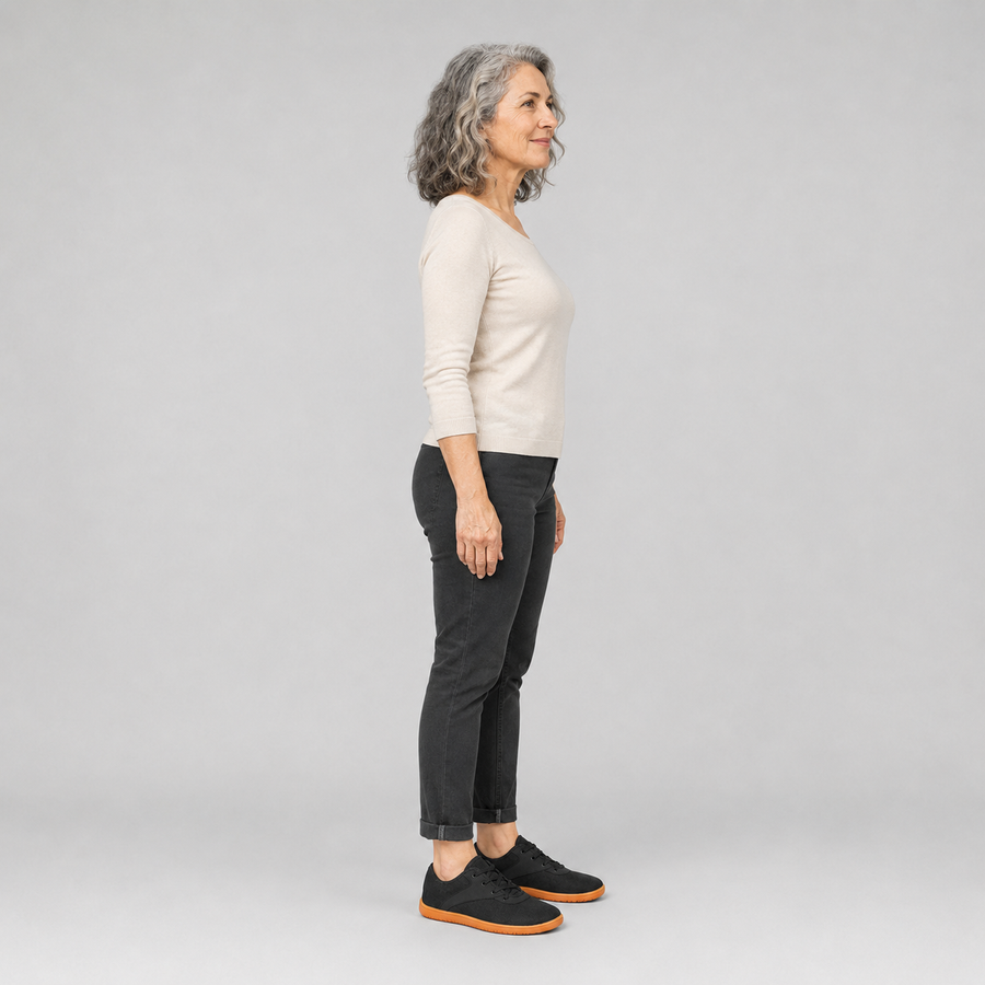 A woman standing in the Anchor shoes, side view showing her hips, knees, ankles and the ball of her foot