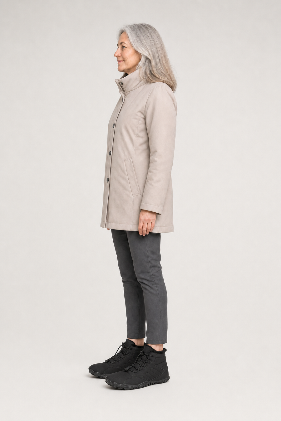 A woman standing in the Arctic boots, side view showing her hips, knees, ankles and the ball of her foot