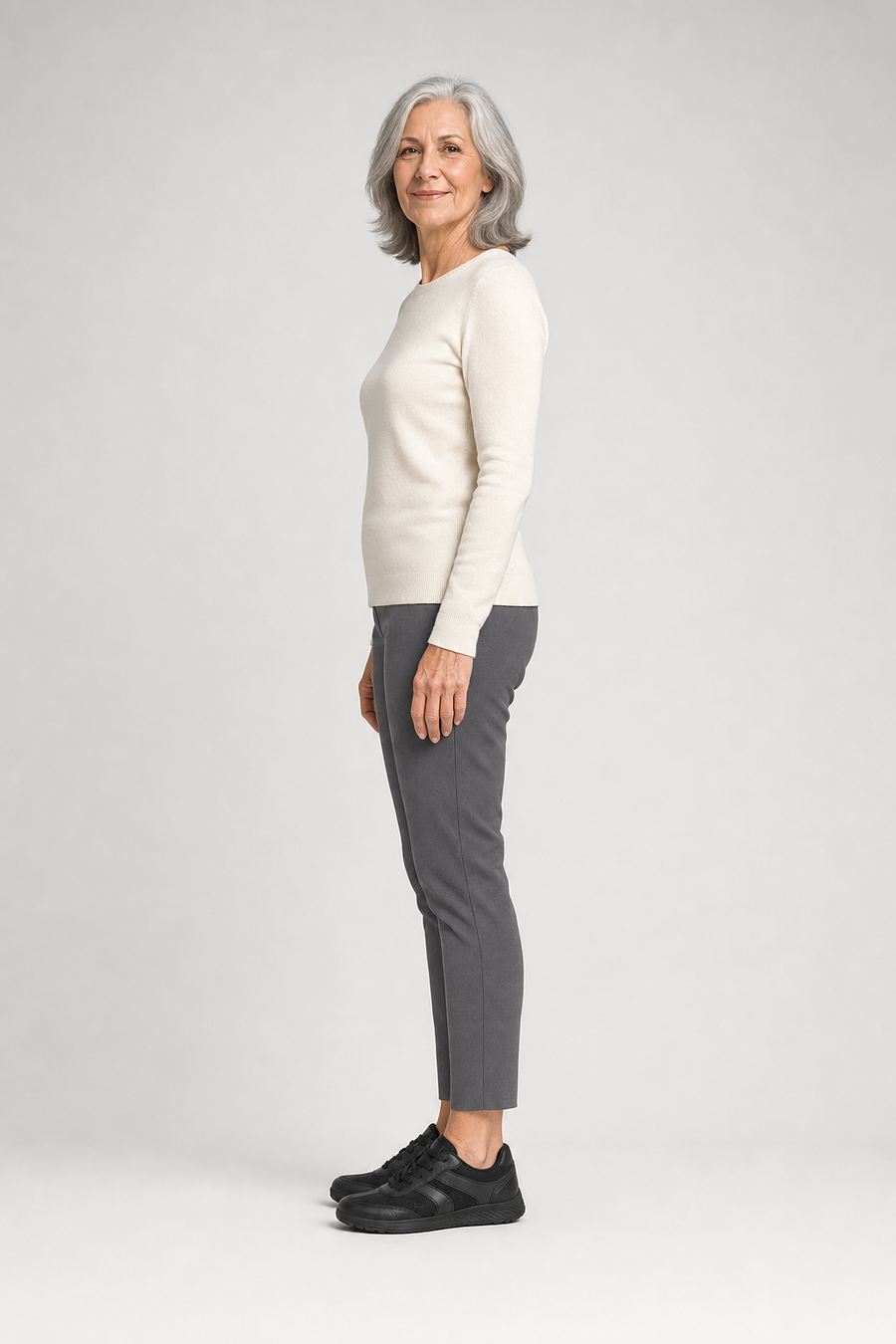 A woman standing in the Boulder shoes, side view showing her hips, knees, ankles and the ball of her foot
