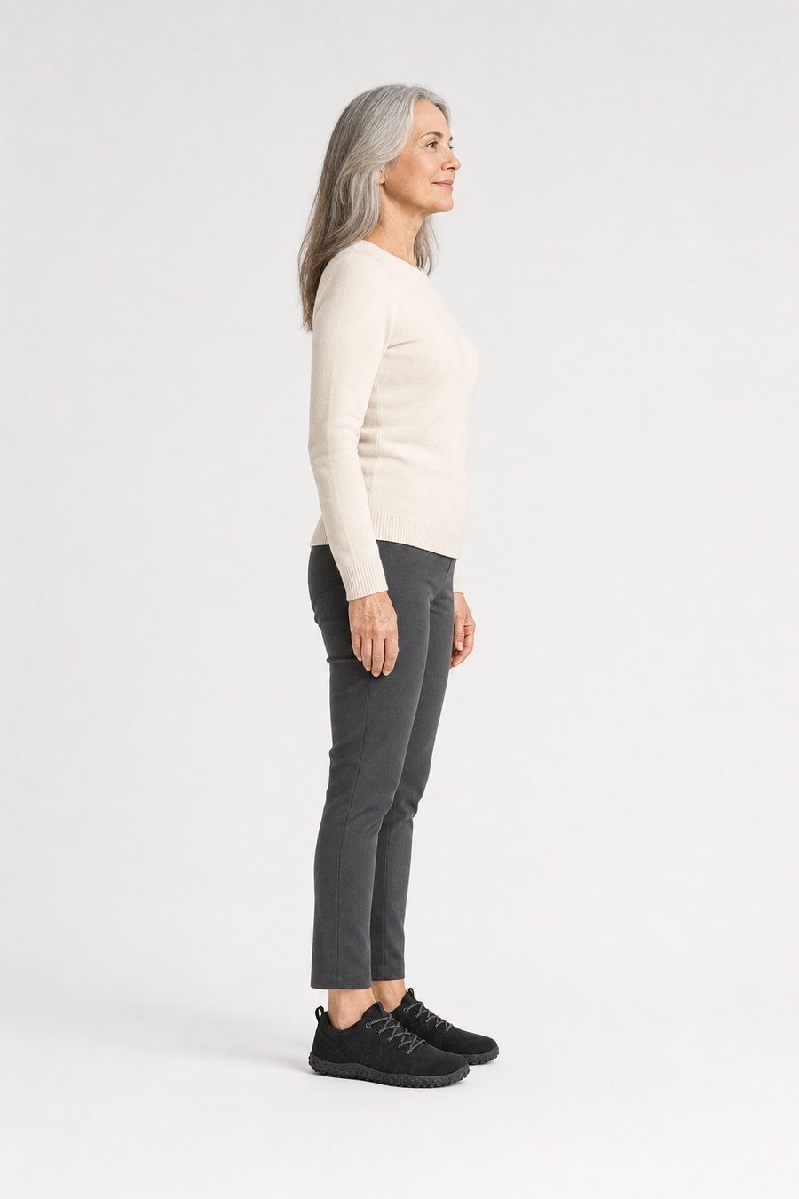 A woman standing in the Granite shoes, side view showing her hips, knees, ankles and the ball of her foot
