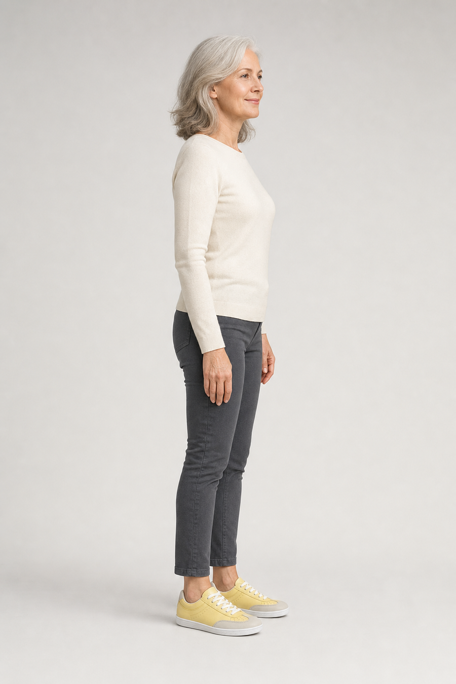 A woman standing in the Rally shoes, side view showing her hips, knees, ankles and the ball of her foot