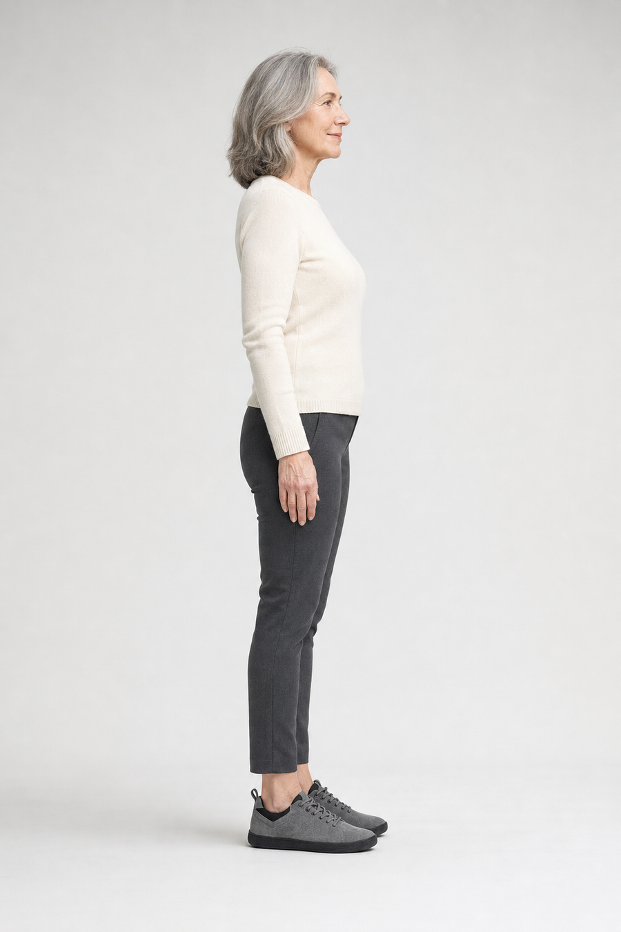A woman standing in the Swift shoes, side view showing her hips, knees, ankles and the ball of her foot